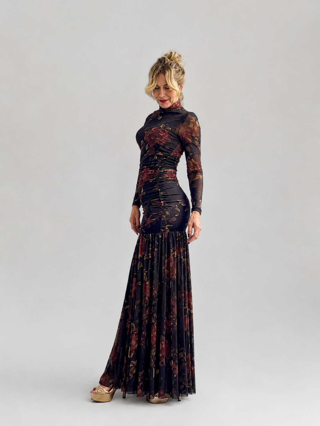 Maxi floral φόρεμα σε σκούρο φόντο με ψηλό λαιμό, μακριά μανίκια, εφαρμοστή μέση και αέρινη πλισέ φούστα.