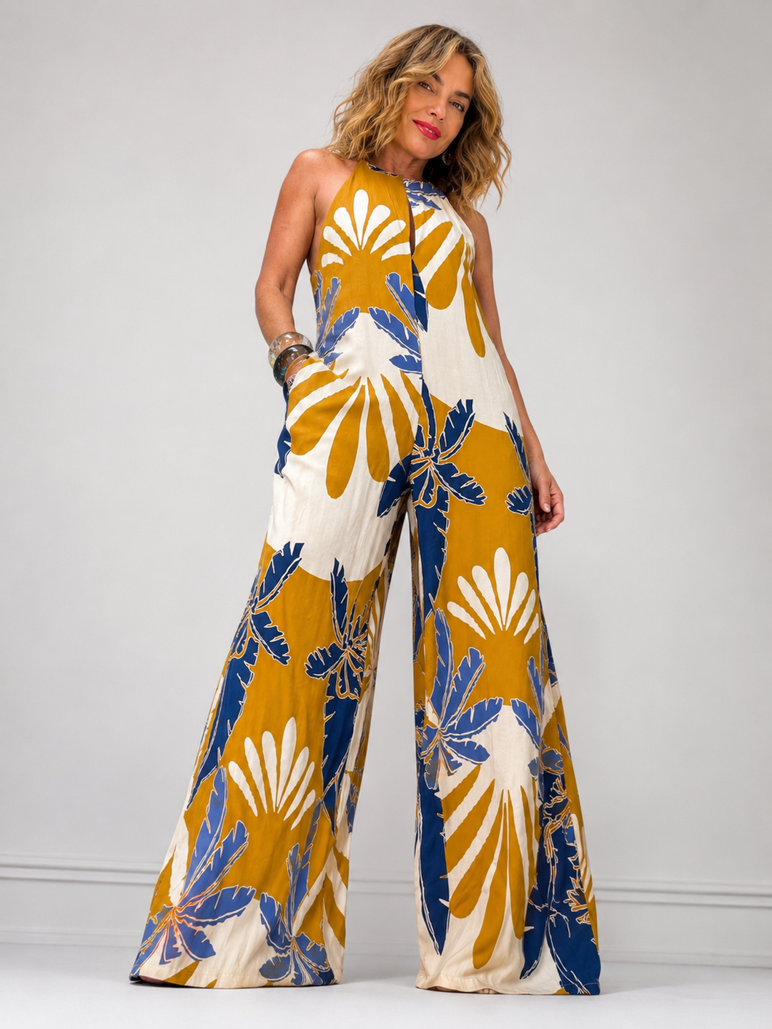 Γυναικεία ολόσωμη φόρμα με tropical print σε μπλε, χρυσή και λευκή απόχρωση με wide-leg εφαρμογή.