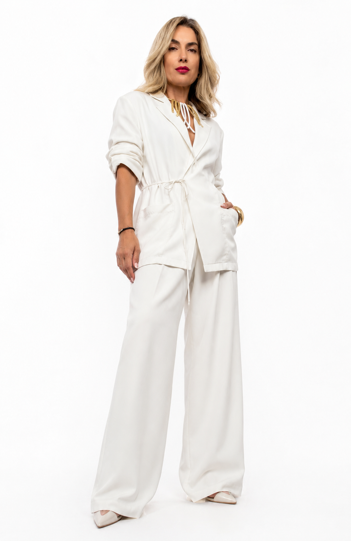 Luxury λευκό γυναικείο κουστούμι με oversized σακάκι και wide leg παντελόνα σε elegant fashion studio